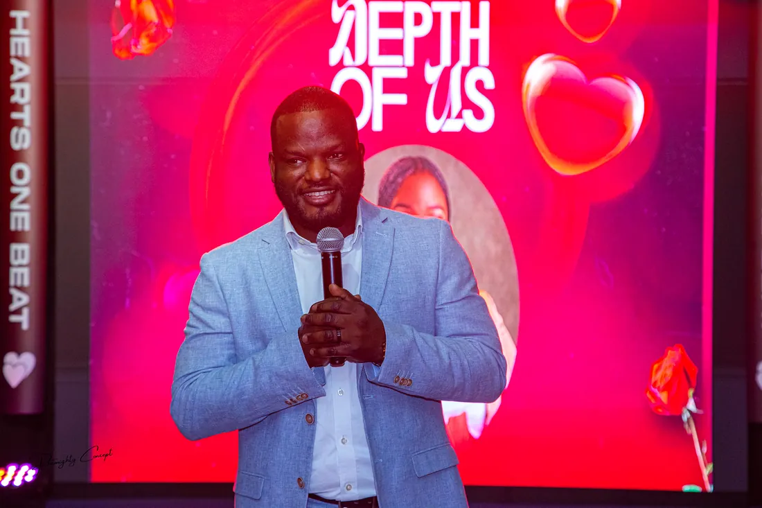 A speaker on the pink-lit stage
