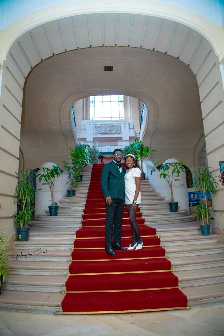 The couple at the top of the grand staircase, framed by the arch