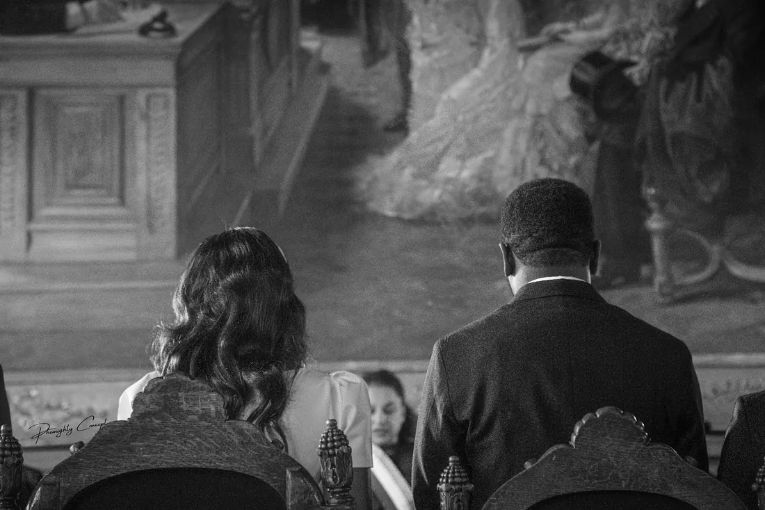 The ceremony seen from behind the couple, in black and white